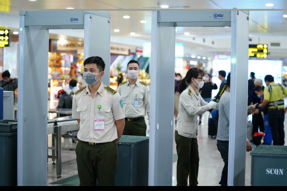 Tại Cảng hàng không quốc tế Nội Bài (Hà Nội), 100% nhân viên thực hiện đeo khẩu trang trong suốt thời gian làm việc và lực lượng an ninh hàng không phải đeo găng tay bảo hộ lao động. (Ảnh: Phan Công/TTXVN)