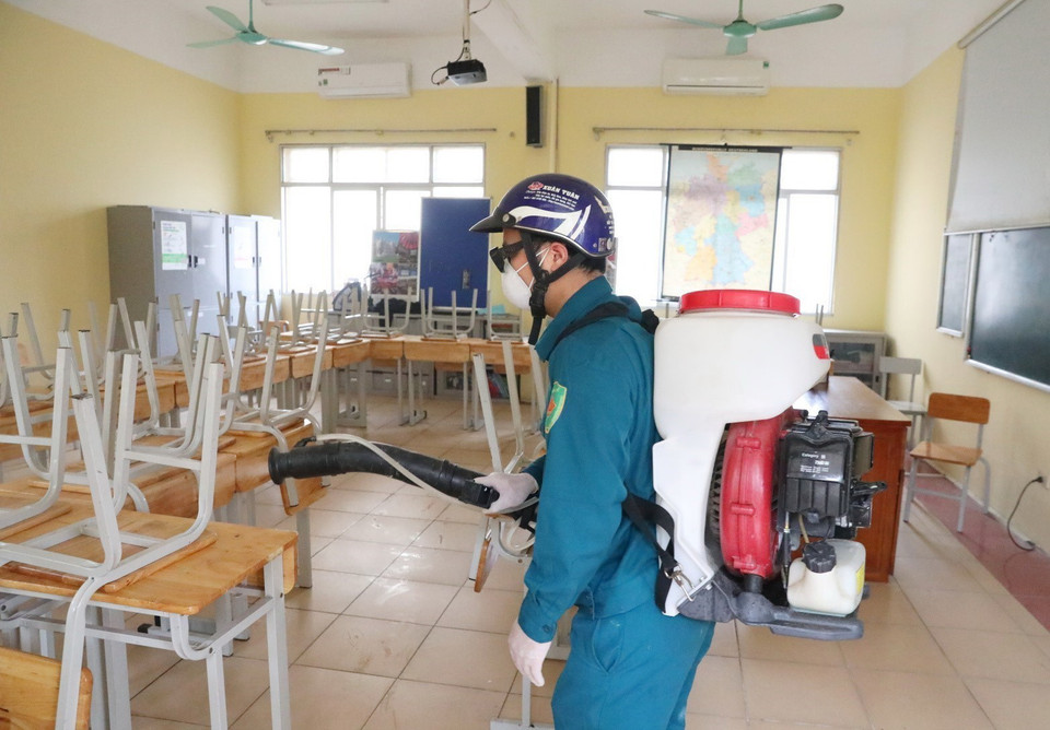  Nhân viên y tế quận Hoàn Kiếm (Hà Nội) phun thuốc khử trùng Chloramin B các phòng học trường THPT Việt Đức. (Ảnh: Thành Đạt/TTXVN)