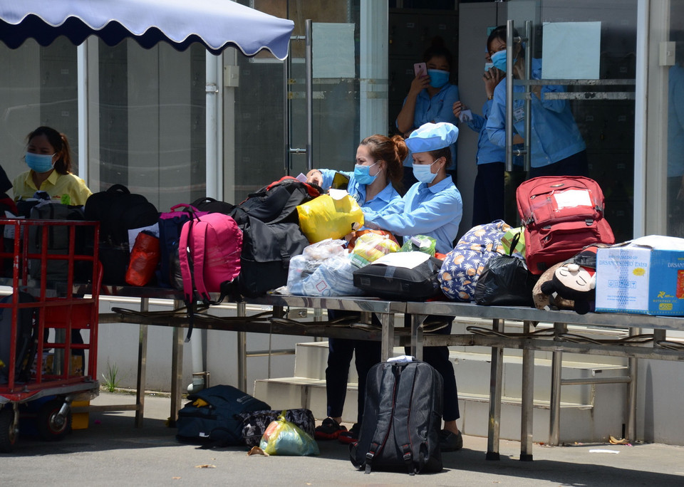  Các công nhân Công ty TNHH Murata Manufacturing Việt Nam Đà Nẵng nhận đồ do người nhà gửi vào trước khi đi cách ly tập trung. (Ảnh: TTXVN)