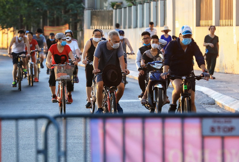  Mặc biển cấm và rào chắn người dân vẫn ra đường đạp xe tập thể dục tại phố Trích Sài dọc ven đường hồ Tây - chụp 6h sáng 16/7. (Ảnh: Thành Đạt/TTXVN)