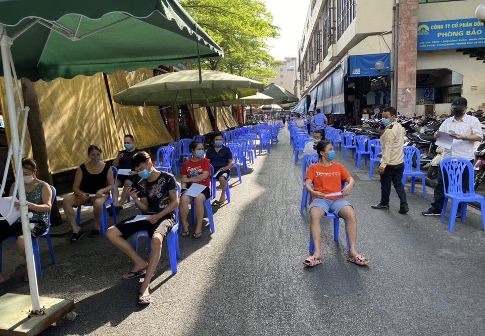  Trung tâm y tế quận Hoàn Kiếm lấy mẫu cho người có nguy cơ cao tại khu vực chợ Đồng Xuân, ngày 15/7. (Ảnh: TTXVN phát)