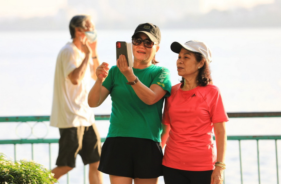  Một số người dân đi tập thể dục còn hồn nhiên bỏ khẩu trang chụp ảnh giữa đại dịch - chụp 7h sáng 16/7. (Ảnh: Thành Đạt/TTXVN)
