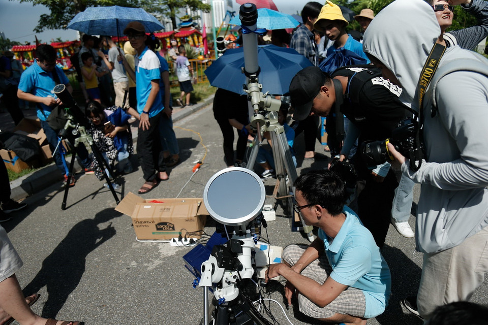 Nhiều nhóm thiên văn nghiệp dư hỗ trợ dụng cụ để người dân ngắm hiện thực nhật thực một phần tại công viên Hòa Bình. (Ảnh: Hoàng Việt/TTXVN)