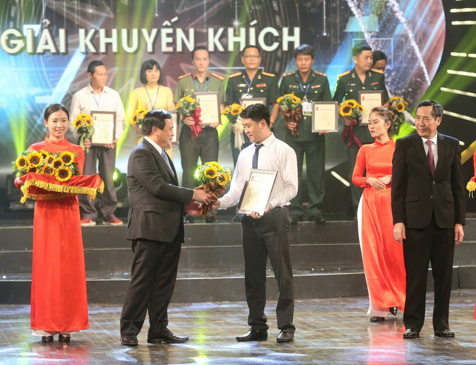 Bí thư Trung ương Đảng, Giám đốc Học viện Chính trị Quốc gia Hồ Chí Minh Nguyễn Xuân Thắng và Ủy viên Trung ương Đảng, Tổng Biên tập báo Nhân Dân, Chủ tịch Hội Nhà báo Việt Nam Thuận Hữu trao Giải Khuyến khích cho tác giả Dương Văn Giang (Ban Biên tập Ảnh, Liên Chi hội Nhà báo TTXVN). (Ảnh: Doãn Tấn/TTXVN)