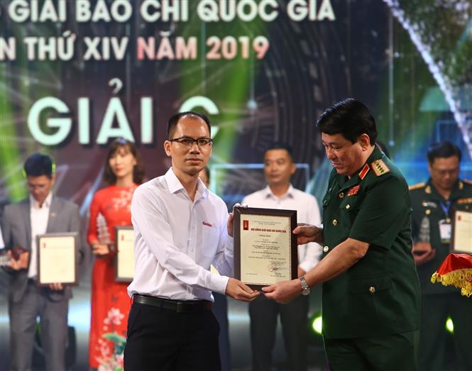 Đại tướng Lương Cường, Bí thư Trung ương Đảng, Chủ nhiệm Tổng cục Chính trị QĐND Việt Nam trao Giải C cho đại diện nhóm tác giả thuộc Chi hội Nhà báo Báo Tin Tức, Liên Chi hội Nhà báo TTXVN. (Ảnh: Minh Quyết/TTXVN)