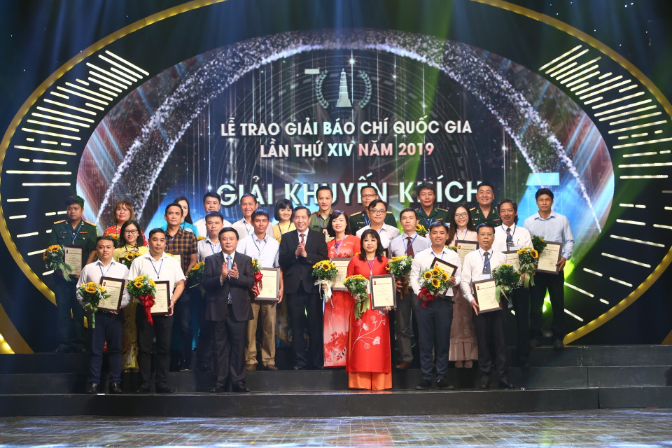 Bí thư Trung ương Đảng, Giám đốc Học viện Chính trị Quốc gia Hồ Chí Minh Nguyễn Xuân Thắng và Ủy viên Trung ương Đảng, Tổng Biên tập báo Nhân Dân, Chủ tịch Hội Nhà báo Việt Nam Thuận Hữu trao Giải Khuyến khích cho các tác giả đoạt giải. (Ảnh: Doãn Tấn/TTXVN)