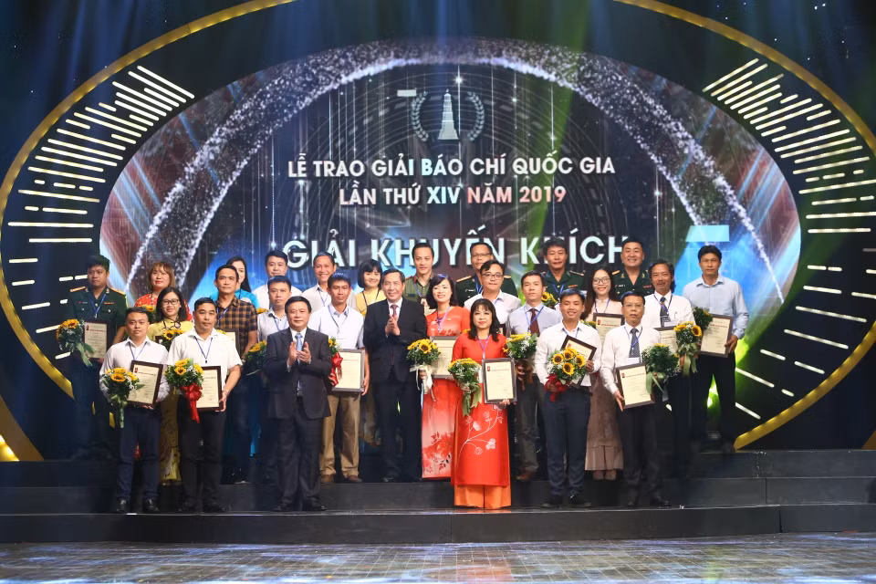 Bí thư Trung ương Đảng, Giám đốc Học viện Chính trị Quốc gia Hồ Chí Minh Nguyễn Xuân Thắng và Ủy viên Trung ương Đảng, Tổng Biên tập báo Nhân Dân, Chủ tịch Hội Nhà báo Việt Nam Thuận Hữu trao Giải Khuyến khích cho các tác giả đoạt giải. (Ảnh: Doãn Tấn/TTXVN)