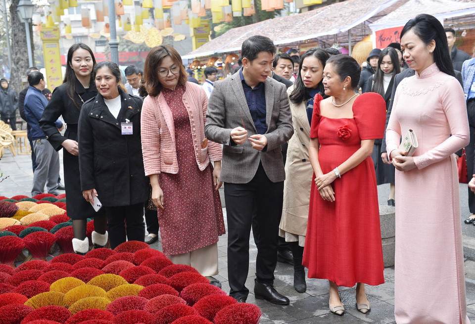 Phu nhân Chủ tịch nước Phan Thị Thanh Tâm và Phu nhân Tổng thống Philippines Louise Araneta Marcos tìm hiểu về các nét văn hóa ngày Tết của Việt Nam qua các gian hàng trưng bày tại phố đi bộ Phùng Hưng (Hà Nội). (Ảnh: Minh Đức/TTXVN)