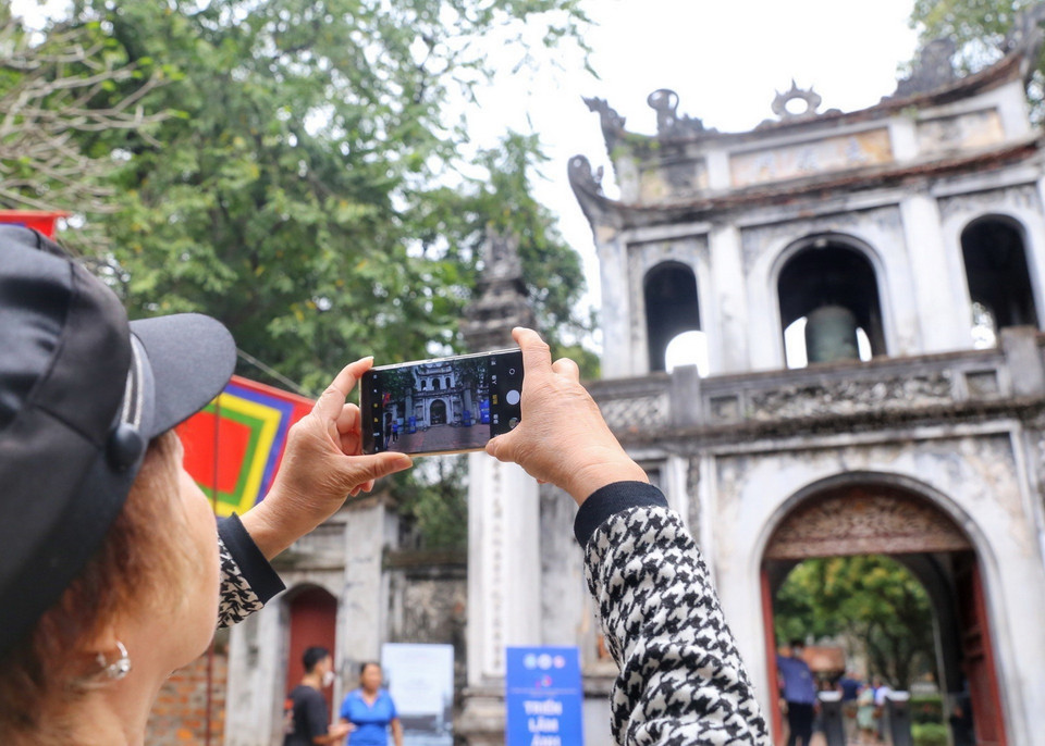 Khách du lịch Trung Quốc chụp ảnh lưu niệm tại Văn Miếu-Quốc Tử Giám. (Ảnh: Tuấn Đức/TTXVN)