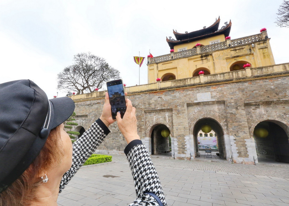 Khách du lịch Trung Quốc chụp ảnh lưu niệm tại Khu di tích trung tâm Hoàng thành Thăng Long. (Ảnh: Tuấn Đức/TTXVN)