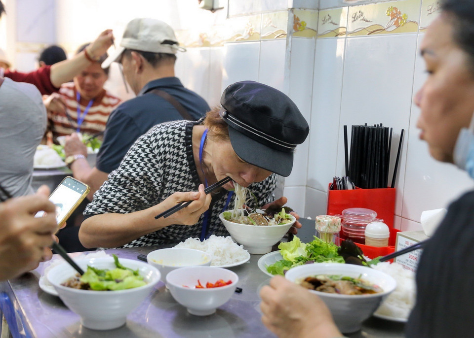 Khách du lịch Trung Quốc thưởng thức bún chả Hà Nội. (Ảnh: Tuấn Đức/TTXVN)