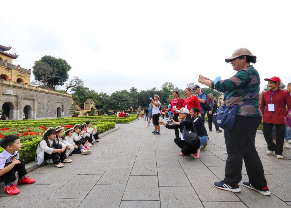 Khách du lịch Trung Quốc chụp ảnh lưu niệm tại Khu di tích trung tâm Hoàng thành Thăng Long. (Ảnh: Tuấn Đức/TTXVN)