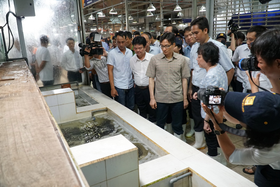 Phó Thủ tướng Vũ Đức Đam thị sát khu vực bán thủy hải sản. (Ảnh: Phương Vy/TTXVN)