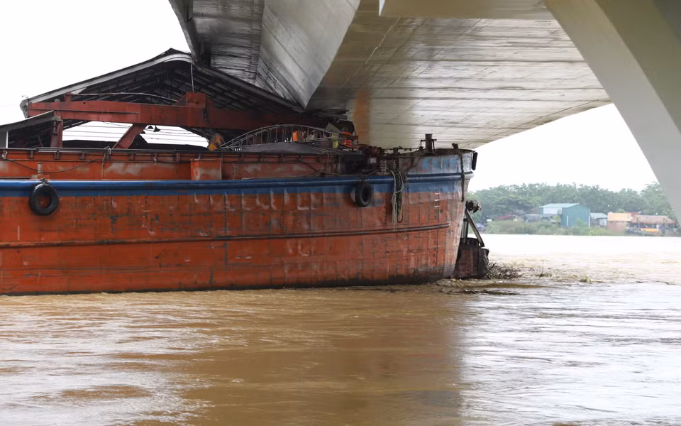 Một tàu chở hàng và sà lan bị mắc kẹt dưới gầm cầu Vĩnh Phú. (Ảnh: Tạ Toàn/TTXVN)