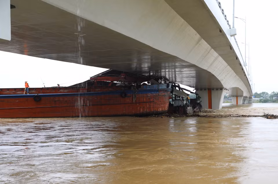 Một tàu chở hàng và sà lan bị mắc kẹt dưới gầm cầu Vĩnh Phú. (Ảnh: Tạ Toàn/TTXVN)