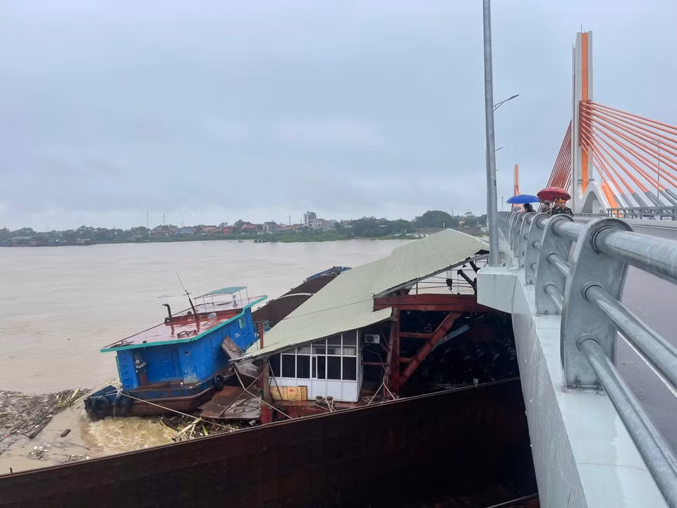 Sà lan lớn mắc kẹt ở cầu Vĩnh Phú, một phần chui vào gầm cầu. (Ảnh: TTXVN phát)
