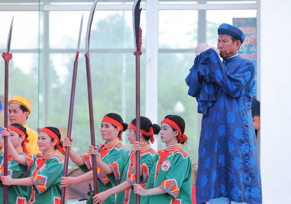 Thổi ốc u khi đưa các hình nhân thế mạng ra biển. (Ảnh: Hoàng Hiếu/TTXVN)