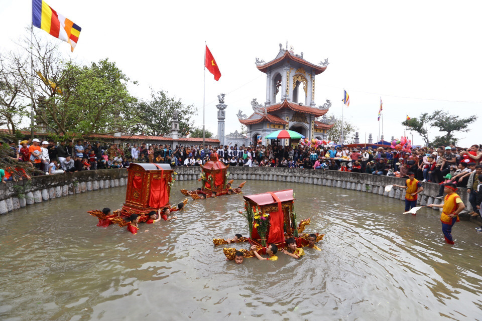 Kiệu quay được rước xuống giếng chùa Phượng Vũ. (Ảnh: Minh Quyết/TTXVN)