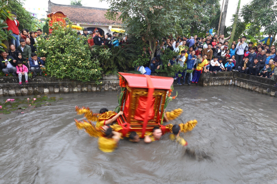 Kiệu được quay trong ao trước Miếu làng Phượng Vũ. (Ảnh: Minh Quyết/TXVN)