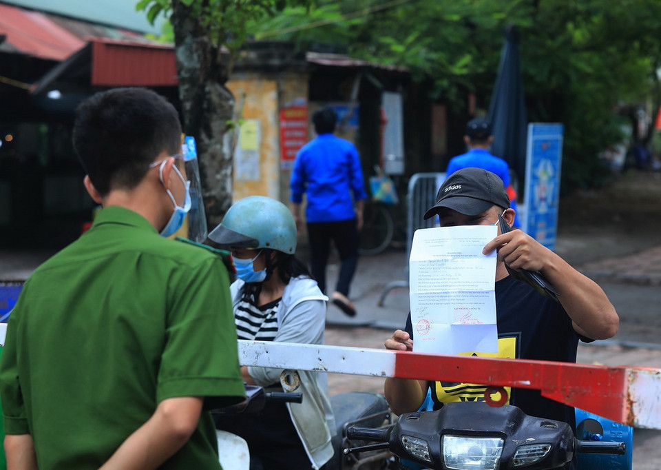  Người đi đường đi qua chốt kiểm dịch dều phải xuất trình giấy đi dường và đứng xa cách 2m. (Ảnh: Tuấn Anh/TTXVN)