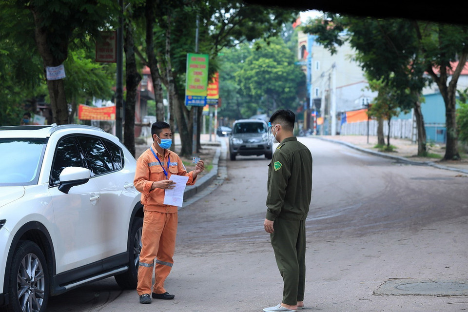  Lực lượng chức năng kiểm tra giấy đi đường của người dân ra vào địa bàn xã. (Ảnh: Tuấn Anh/TTXVN)
