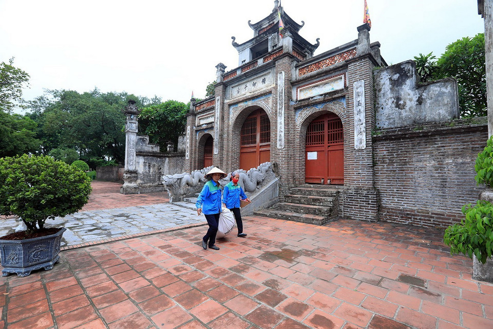  Các công nhân vệ sinh môi trường thu dọn rác tại di tích Cổ Loa đảm bảo môi trường sạch, đẹp. (Ảnh: Minh Quyết/TTXVN)