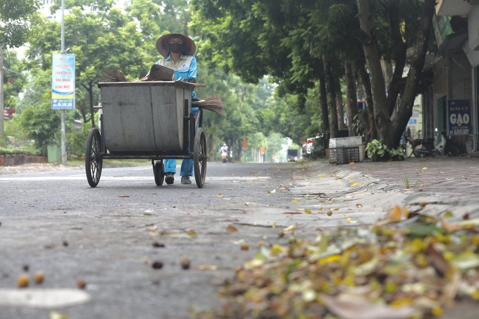  Nhân viên vệ sinh môi trường xã Cổ Loa đảm bảo vệ sinh đường phố, hạn chế sự lây lan của dịch bệnh. (Ảnh: Minh Quyết/TTXVN)