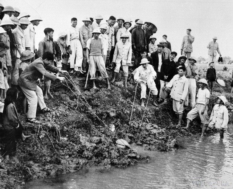 Chủ tịch Hồ Chí Minh đến thăm và tham gia tát nước chống hạn cùng nông dân xã Đại Thanh, Hà Đông (nay là Hà Nội), ngày 12/1/1958. (Ảnh: TTXVN)