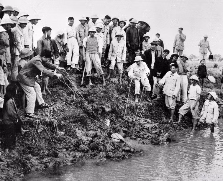 Chủ tịch Hồ Chí Minh đến thăm và tham gia tát nước chống hạn cùng nông dân xã Đại Thanh, Hà Đông (nay là Hà Nội), ngày 12/1/1958. (Ảnh: TTXVN)