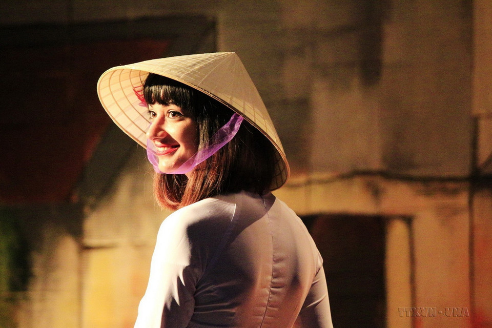 Thiếu nữ Italy duyên dáng trong tà áo dài và chiếc nón lá truyền thống Việt Nam tại chương trình trình diễn áo dài, nón “Bài thơ” tại Liên hoan Sinh viên Việt Nam 2018 ở Italy, ngày 9/5/2018. (Ảnh: Quang Thanh/TTXVN)