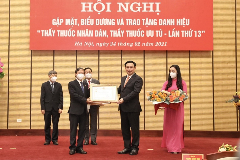 Ủy viên Bộ Chính trị, Bí thư Thành ủy Hà Nội Vương Đình Huệ trao danh hiệu Thầy thuốc Nhân dân cho Tiến sỹ Hoàng Đức Hạnh, Phó Giám đốc Sở Y tế Hà Nội. (Ảnh: Minh Quyết/TTXVN)