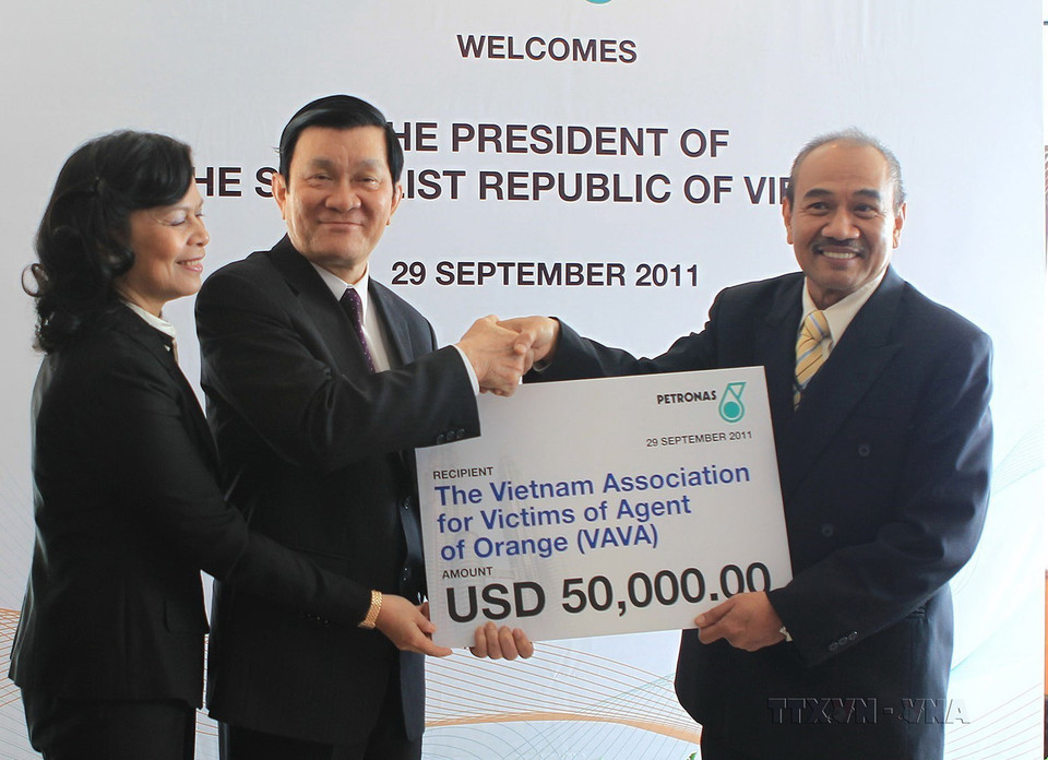 Lãnh đạo Tập đoàn Dầu khí Petronas (Malaysia) trao cho Chủ tịch nước Trương Tấn Sang số tiền 50.000 USD tặng nạn nhân chất độc da cam/dioxin ở Việt Nam, nhân chuyến thăm cấp Nhà nước của Chủ tịch đến Malaysia, ngày 29/9/2011. (Ảnh: Nguyễn Khang/TTXVN)