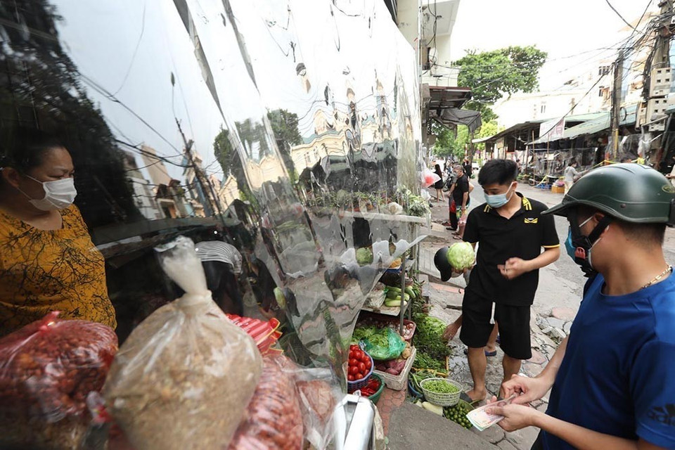 Tại khu vực chợ Bách Khoa, quận Hai Bà Trưng, cơ quan chức năng lắp hàng rào nylon đảm bảo giãn cách, ngăn giọt bắn. (Ảnh: Minh Quyết/TTXVN)