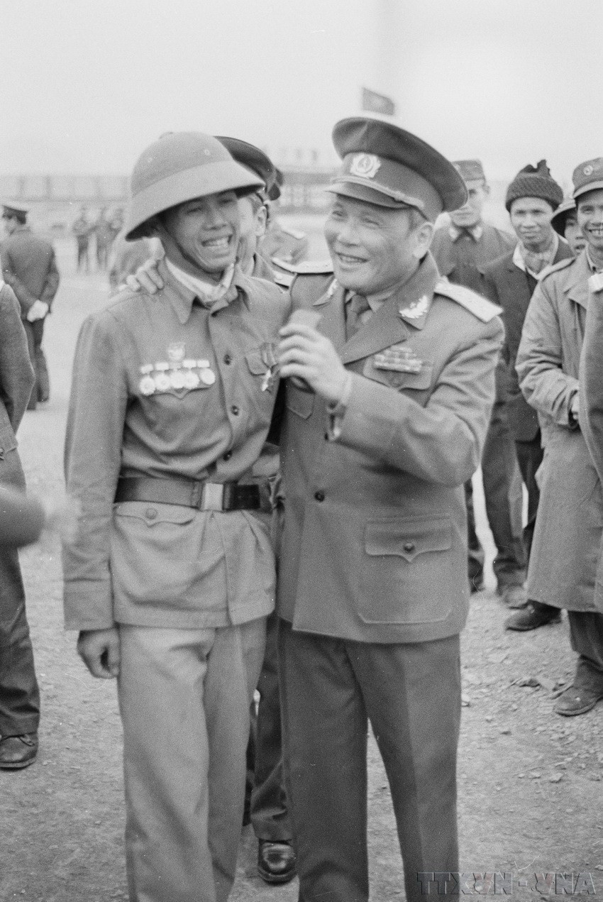 Đại tướng Chu Huy Mân khen ngợi chiến sỹ Hoàng Văn Nhằm, xã đội trưởng xã Oai Ninh, huyện Hữu Lũng (Lạng Sơn) 8 năm liền đạt danh hiệu chiến sỹ quyết thắng có thành tích trong chiến đấu chiến tranh biên giới phía Bắc (1984). (Ảnh: Minh Điền/TTXVN)