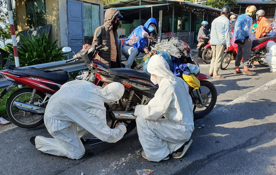  Sinh viên tình nguyện trong đội SOS của trường Đại học Đông Á Đà Nẵng sửa chữa xe miễn phí cho người dân các tỉnh, thành trên đường trở về nhà khi đi qua thành phố Đà Nẵng. (Ảnh: TTXVN phát)