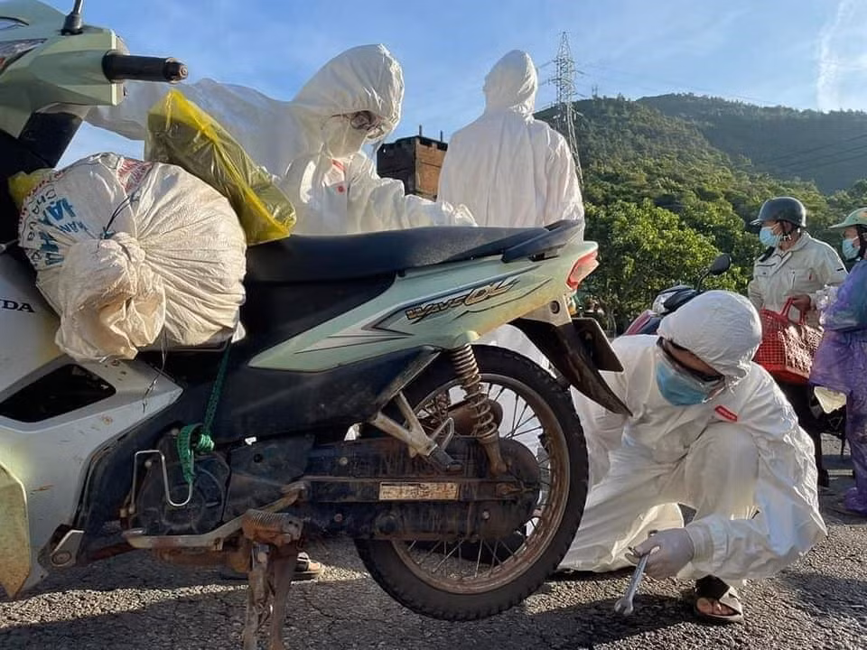  Sinh viên tình nguyện trong đội SOS của trường Đại học Đông Á Đà Nẵng sửa chữa xe miễn phí cho người dân trên đèo Hải Vân. (Ảnh: TTXVN phát)