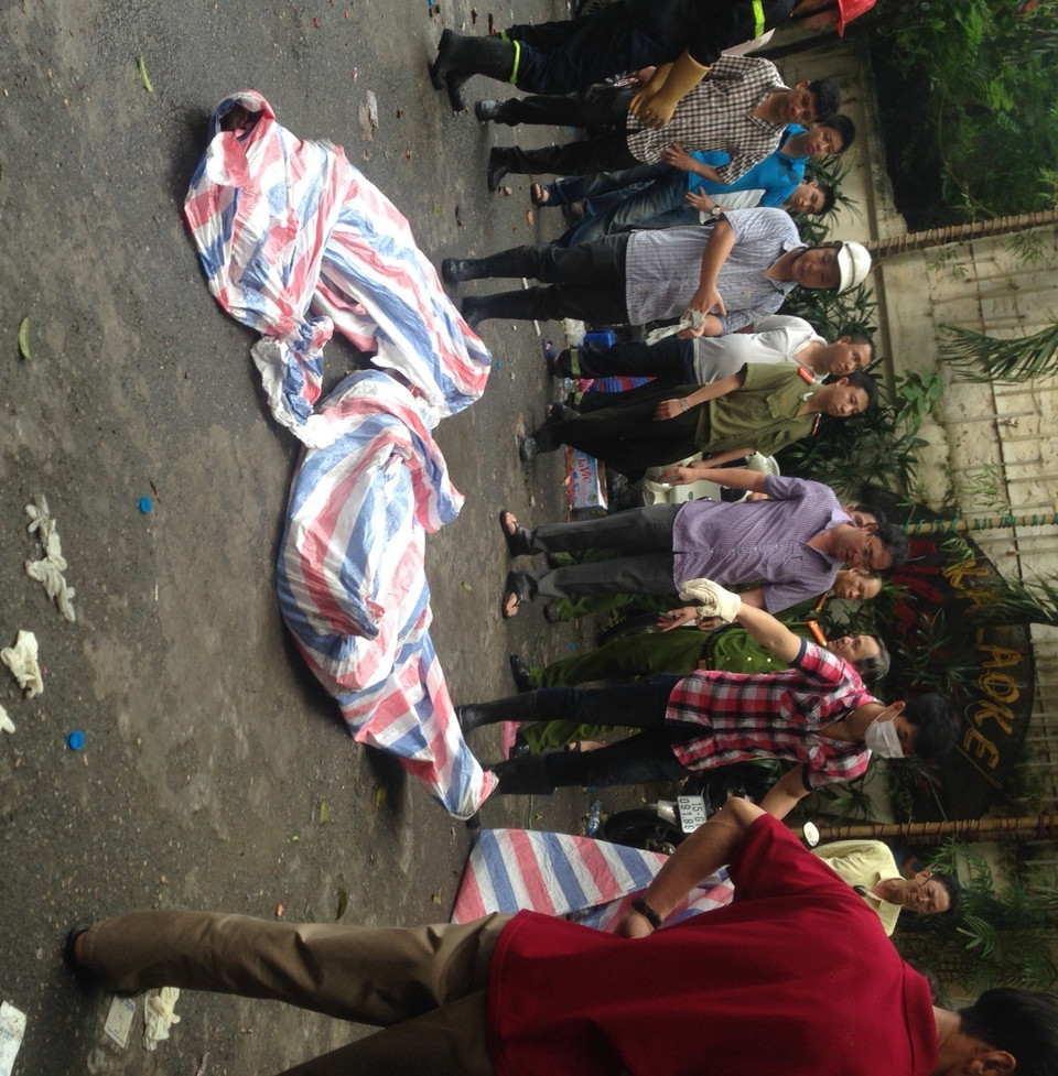 Đưa xác nạn nhân ra ngoài. (Ảnh: Sơn Bách/Vietnam+)