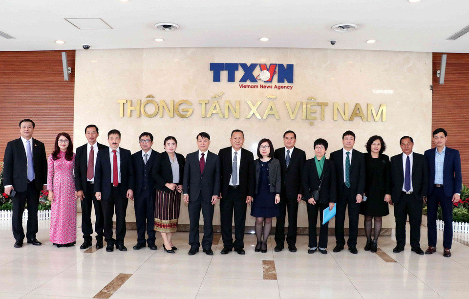 Tổng Giám đốc TTXVN Nguyễn Đức Lợi tặng quà lưu niệm Tổng Giám đốc Thông tấn Pathet Lào (KPL) Sounthone Khanthavong. (Ảnh: Văn Điệp/TTXVN)