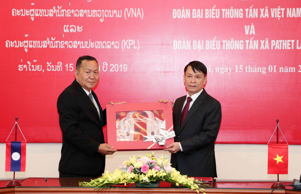 Tổng Giám đốc TTXVN Nguyễn Đức Lợi tặng quà lưu niệm Tổng Giám đốc Thông tấn Pathet Lào (KPL) Sounthone Khanthavong. (Ảnh: Văn Điệp/TTXVN)