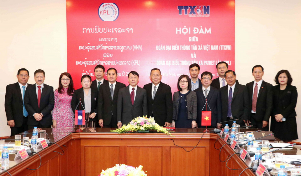 Tổng Giám đốc TTXVN Nguyễn Đức Lợi và Tổng Giám đốc Thông tấn Pathet Lào (KPL) Sounthone Khanthavong với các đại biểu. (Ảnh: Văn Điệp/TTXVN)