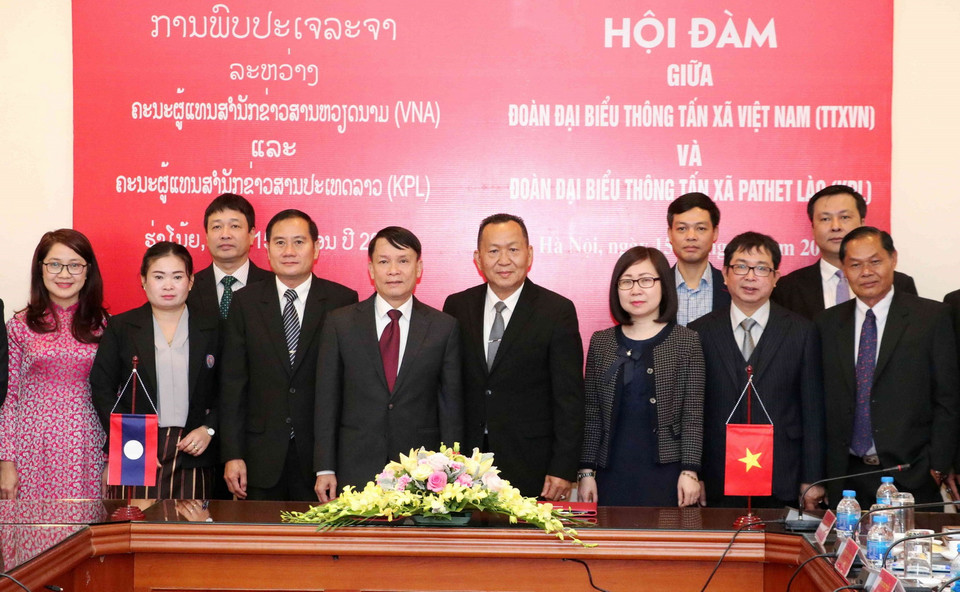 Tổng Giám đốc TTXVN Nguyễn Đức Lợi và Tổng Giám đốc Thông tấn Pathet Lào (KPL) Sounthone Khanthavong với các đại biểu. (Ảnh: Văn Điệp/TTXVN)