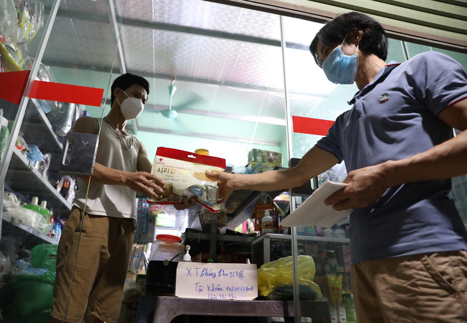 Các cửa hàng thiết yếu rất hạn chế bán hàng trực tiếp, chủ yếu sử dụng chuyển khoản và giao hàng đến tận nhà, tại tổ dân phố My Diềm 1. (Ảnh: Danh Lam/TTXVN)