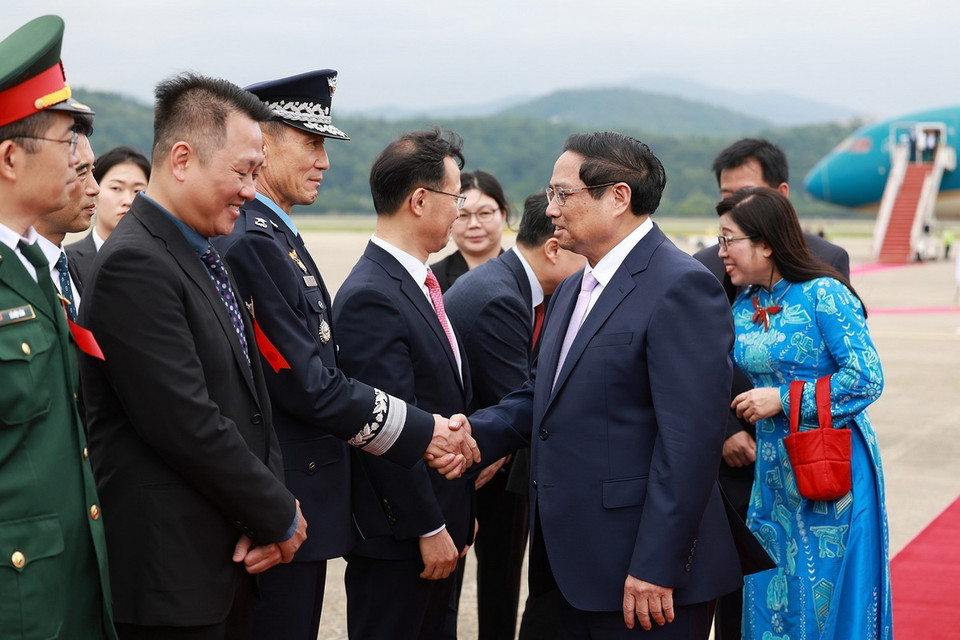 Quan chức Hàn Quốc đón Thủ tướng Phạm Minh Chính và Phu nhân tại Sân bay quân sự Seongnam, tỉnh Gyeonggi. (Ảnh: Dương Giang/TTXVN)