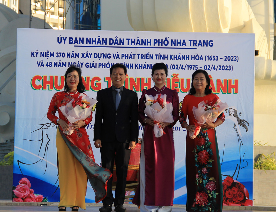 Ông Phan Thanh Liêm, Phó Chủ tịch Ủy ban Nhân dân thành phố Nha Trang, Trưởng Ban vì sự tiến bộ phụ nữ thành phố tặng hoa cho đại diện các chị phụ nữ tham gia diễu hành áo dài. (Ảnh: Phan Sáu/TTXVN)