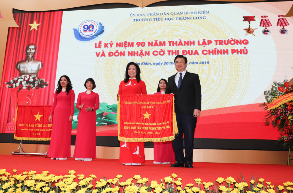 Thứ trưởng Bộ Giáo dục và Đào tạo Nguyễn Hữu Độ trao Cờ thi đua của Chính phủ tặng Trường Tiểu học Thăng Long. (Ảnh: Thanh Tùng/TTXVN)