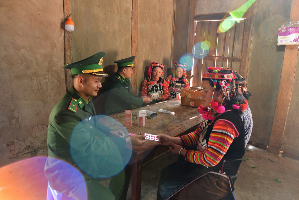 Cán bộ Đồn Biên phòng A Pa Chải khám chữa bệnh và phát thuốc cho bà con người dân tộc Hà Nhì tại nhà. (Ảnh: Minh Đức/TTXVN)
