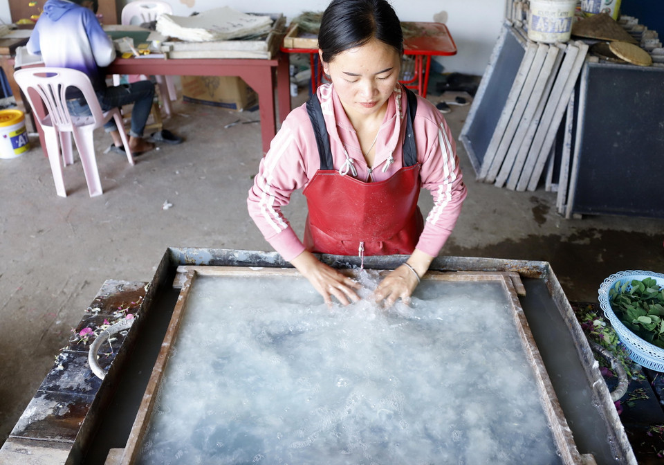 Công đoạn dàn bột giấy trên khuôn. (Ảnh: Phạm Kiên/TTXVN)