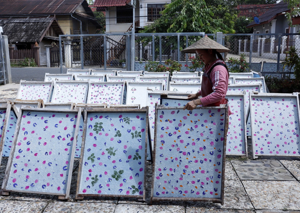 Giấy Saa sau khi được lên khung, trang trí được mang đi phơi nắng. (Ảnh: Phạm Kiên/TTXVN)