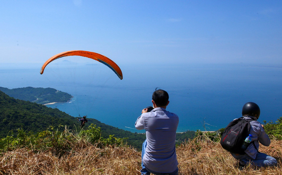 Người dân hào hứng xem các vận động viên thi dù lượn. (Ảnh: Trần Lê Lâm/TTXVN)
