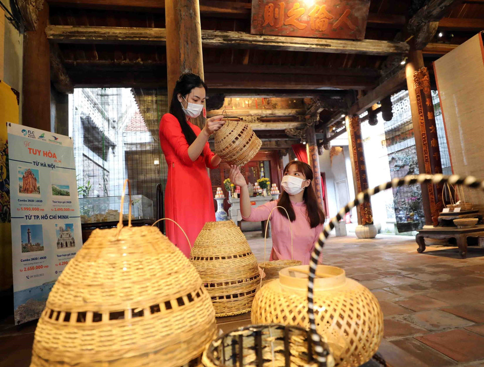 Du khách tham quan đền Quan Đế, tìm hiểu về các sản phẩm mây tre đan truyền thống. (Ảnh: Thanh Tùng/TTXVN)